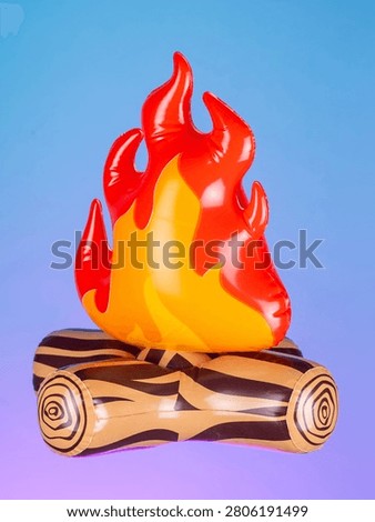 Close-up of an inflatable campfire with logs on a purple background, showcasing its bright colors and playful design