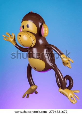 Close-up of an inflatable monkey toy on a purple background, highlighting its playful design and vibrant colors.