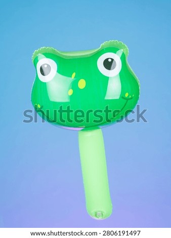 Close-up of an inflatable stick with frog-shaped inflatables on a purple background, highlighting its playful and fun design.