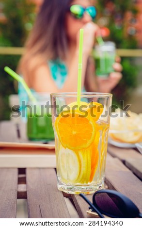 Infused fruit water cocktails and woman drinking green smoothie