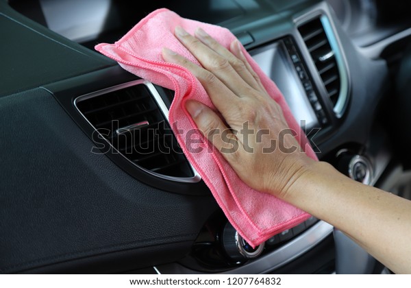 Closeup of inner side car cleaning  with pink 
microfiber cloth by woman owner's hand in sunny day. The lovely
simply family activity.