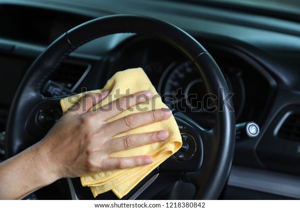 Closeup of inner side car cleaning  with yellow\
microfiber cloth by woman owner\'s hand in sunny day. The lovely\
simply family activity.
