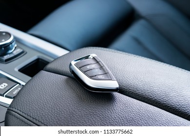 Closeup Inside Vehicle Of Wireless Key Ignition. Start Engine Key. Car Key Remote In Black Perforated Leather Interior. Modern Car Background. Modern Car Interior Details. Car Detailing. Keys Close Up