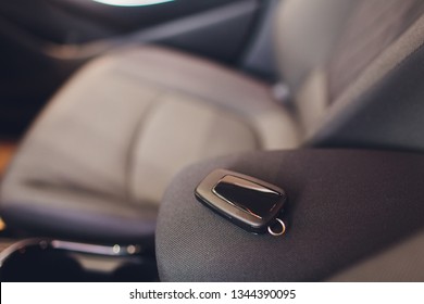 Closeup inside vehicle of wireless key ignition. Start engine key. Car key remote in black perforated leather interior. Modern car background. Modern car Interior details. Car detailing. Keys close up - Powered by Shutterstock