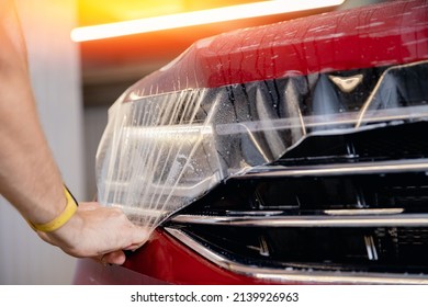 Closeup Installing Protective Transparent Vinyl Film To Protect Paint And Varnish Of Car.