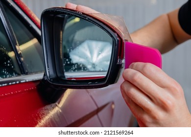 Closeup Installs Vinyl Film For Protect Paint Body Side Mirrors Red Car.