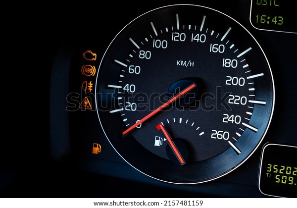 Close-up Instrument car panel with speedometer, low\
fuel level, ABS and other icons. Engine start and stop. Fuel crisis\
concept. High price for a diesel, gasoline, oil and natural\
resources. Red lit.