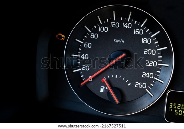 Close-up Instrument car panel with speedometer, low\
fuel level, ABS and other icons. Engine start and stop. Fuel crisis\
concept. High price for a diesel, gasoline, oil and natural\
resources. Red lit.