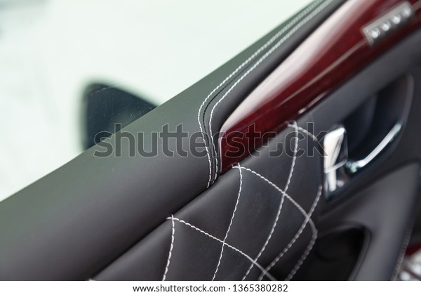 Close-up of\
interior of a luxury car with leather interior overtightened\
stitching in the form of a diamond of white thread in a vehicle\
repair shop. Design atelier auto\
service.