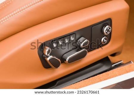 Close-up Interior view with electric comfortable seat with orange leather adjustment, memory buttons of luxury very expensive car	