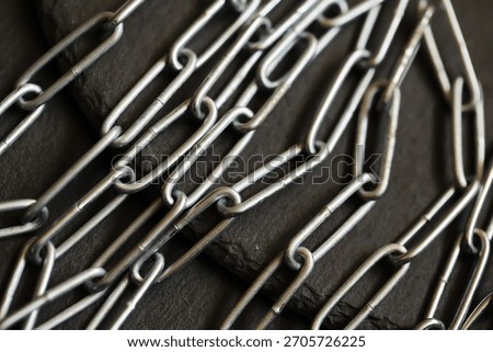 Close-Up of Interlinked Metal Chains on Dark Surface: Strength, Connection, Unity, Industrial, Security