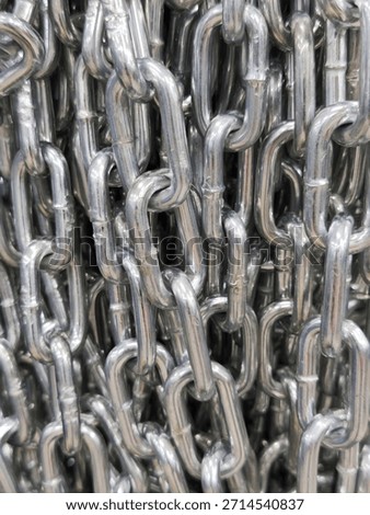 Close-up of interlinked metal chains with shiny steel texture and dense industrial arrangement