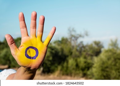 Closeup Of The Intersex Flag Painted In The Palm Of The Hand Of A Young Person, On A Country Landscape