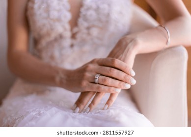 A close-up, intimate shot capturing the delicate hands of a Caucasian bride in a white lace wedding dress