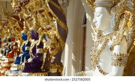 A close-up of intricately adorned Buddha statues at Wat Phasornkaew, featuring detailed golden decorations and vibrant colors. The statues are elegantly crafted, representing Thai spiritual artistry. - Powered by Shutterstock