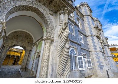 A close-up of an intricately carved entrance to a historic palace. The doorway is framed by a twisted column and an ornate archway, both adorned with intricate carvings. Pena Palace, Portugal. - Powered by Shutterstock