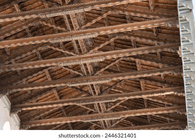 A close-up of an intricately designed wooden ceiling, displaying fine craftsmanship and historic architectural detail. - Powered by Shutterstock