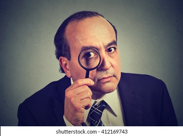 Closeup Investigator Business Man Looking With Magnifying Glass Isolated On Gray Wall Background 