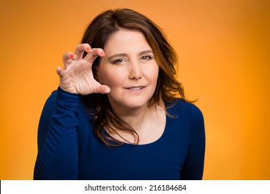 Closeup irritated, stressed unhappy angry mad young woman, threatening someone with her claws nails,isolated orange background. Negative human emotion facial expression feeling reaction body language