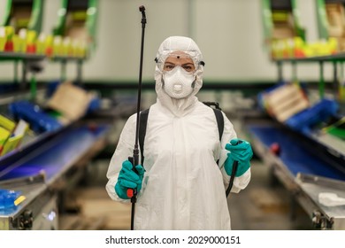 Close-up of an isolated professional female person in protective clothes, gloves and sprayer for cleaning and disinfecting the coronavirus area in an indoor space COVID19 prevention pandemic situation - Shutterstock ID 2029000151