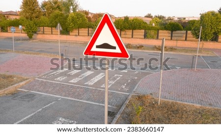 Closeup of an italian road signs indicating the danger due to the presence of a speed bump.