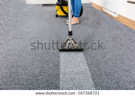 Close-up Of A Janitor Cleaning Carpet With Vacuum Cleaner