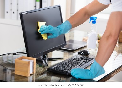 Close-up Of A Janitor's Hand Wearing Gloves Cleaning Computer Screen With Rag