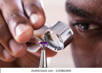 Close-up Of Jeweler Examining Diamond Through Loupe