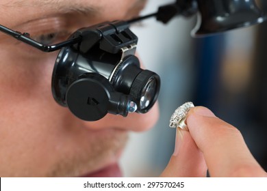 Close-up Of Jeweler Looking Ring Through Magnifying Loupe