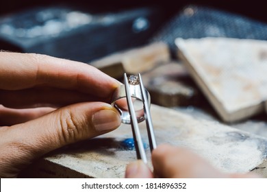 Closeup of Jeweler setting a precious stone with pincers on a ring
