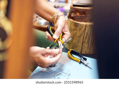 Close-up of jeweler's hands crafting a unique piece of jewelry - Powered by Shutterstock