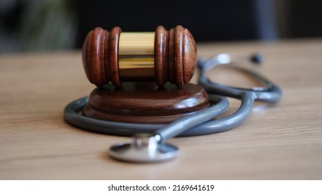 Close-up Of Judge Gavel And Doctor Stethoscope On Lawyer Office Desk. Medical Malpractice, Personal Injury Lawyer And Healthcare Legal Aspects Concept