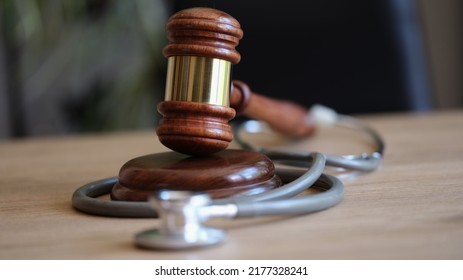 Close-up Of Judge Gavel And Medical Stethoscope On Office Desk. Medical Malpractice Or Personal Injury Lawyer. Healthcare Legal Aspects Concept