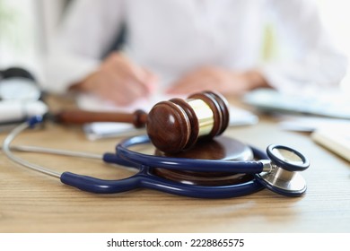 Close-up of judge hammer and doctor stethoscope on office desk. Medical malpractice, personal injury lawyer and healthcare legal aspects concept - Shutterstock ID 2228865575