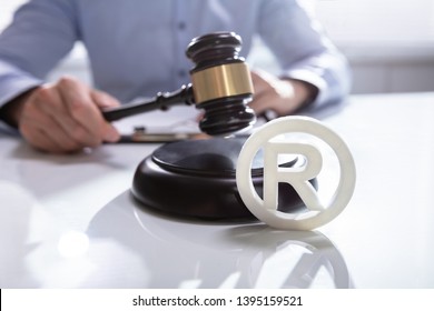 Close-up Of Judge Striking Mallet On Trademark Copyright Symbol