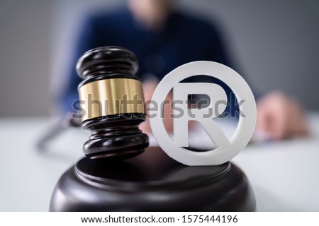 Close-up Of Judge Striking Mallet On Trademark Copyright Symbol