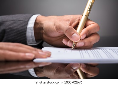 Close-up Of A Judge Writing On Document With Pen