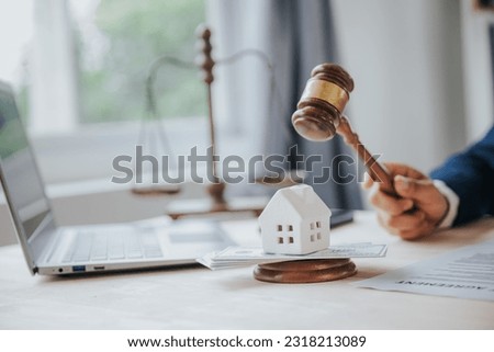Close-up of a judge's hammer small wooden toy house On the table in the courtroom concept of real estate law division of property Land separation and divorce
