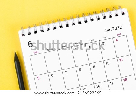 Close-up June 2022 desk calendar on yellow background.