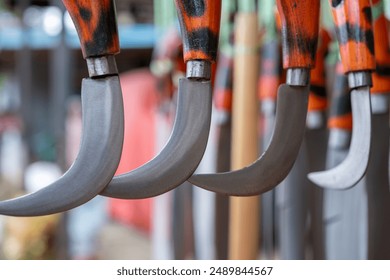 close-up of a karambit knife hanging using a plastic rope in a souvenir shop of traditional Indonesian weapons. Wrought iron crafts sharp weapons wallpapper concept