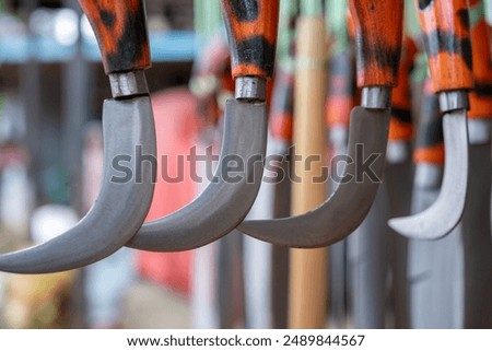 close-up of a karambit knife hanging using a plastic rope in a souvenir shop of traditional Indonesian weapons. Wrought iron crafts sharp weapons wallpapper concept