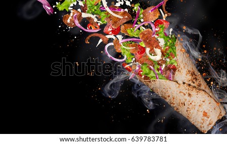 Close-up of kebab sandwich with flying ingredients. Freeze motion.