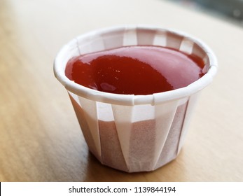 closeup of ketchup tomato sauce in a paper cup with blurred background under natural light - Shutterstock ID 1139844194