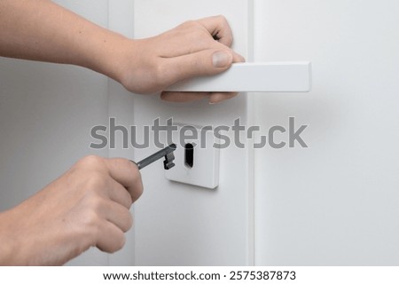 Close-up of a key being inserted into a door lock, closing and opening the door
