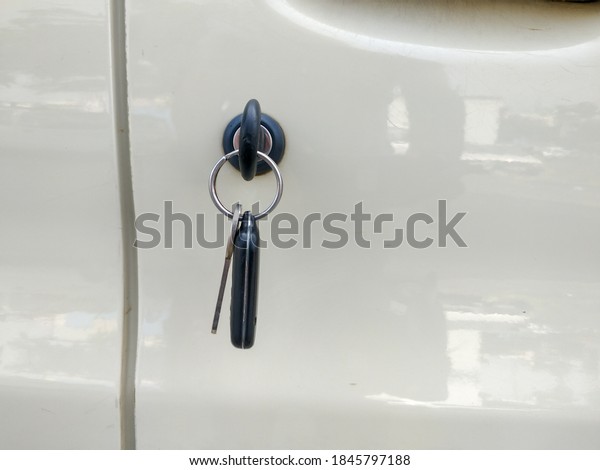 Closeup of a key hooked\
to door of a car.