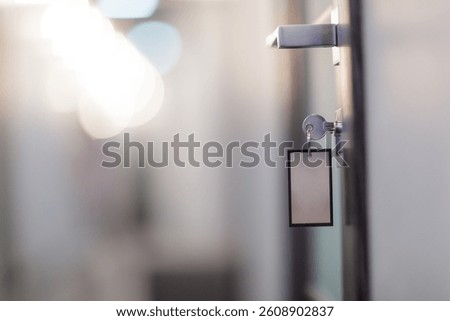 Close-up of a key inserted in a modern door lock with blank key tag, symbolizing security and access.
