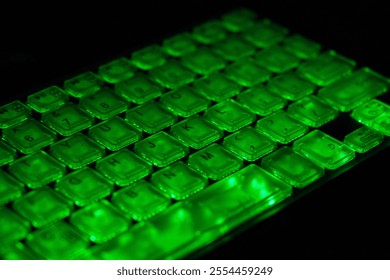 Close-up of a keyboard with bright green illuminated keys. The background is dark, highlighting the keyboard. Illuminated green Keyboard in the Dark Background. - Powered by Shutterstock