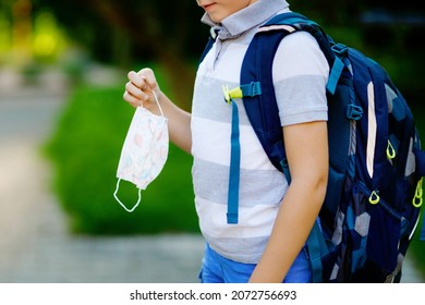 Close-up Of Kid Boy With Medical Mask And Backpack Or Satchel. Schoolkid On Way To School. Child Outdoors. Back To School After Quarantine Time From Corona Pandemic Disease Lockdown. No Face.