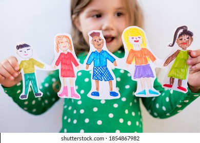 Close-up kid girl holding paper homemade garland with painted children of different races. Happy  international  children s day - Powered by Shutterstock