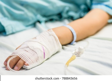 Closeup kid hand  sleeps on a bed in hospital with saline intravenous. - Powered by Shutterstock